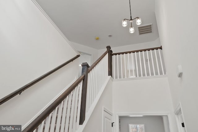 stairs with visible vents and a high ceiling
