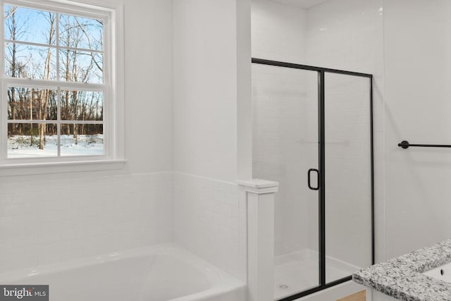full bathroom with a garden tub, a sink, a wealth of natural light, and a stall shower