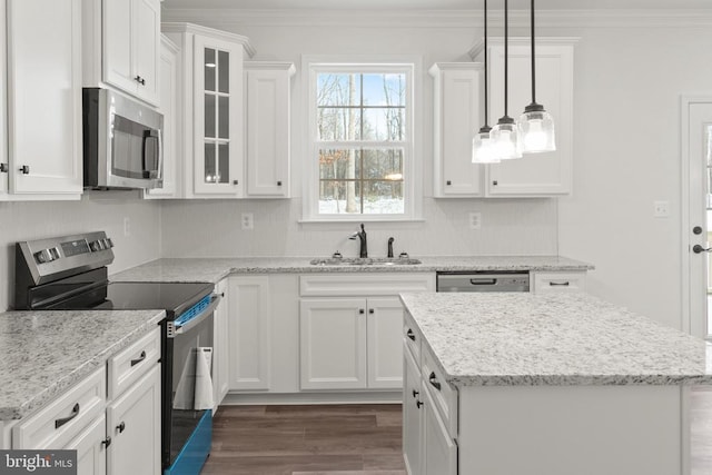 kitchen with white cabinets, stainless steel appliances, a sink, and ornamental molding