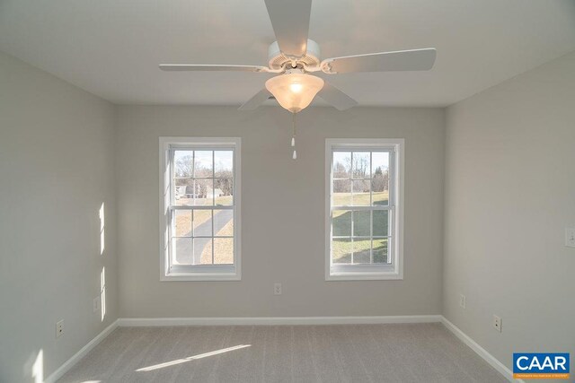 spare room with light carpet, baseboards, and a ceiling fan