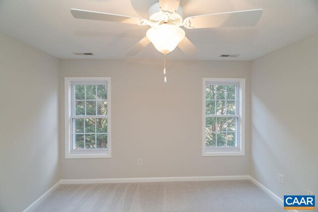 carpeted empty room with a ceiling fan, visible vents, and baseboards