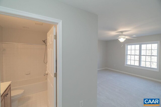 full bathroom featuring shower / bathtub combination, toilet, a ceiling fan, vanity, and baseboards