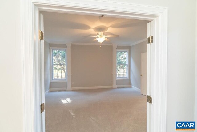 unfurnished room with light carpet, baseboards, ornamental molding, and ceiling fan