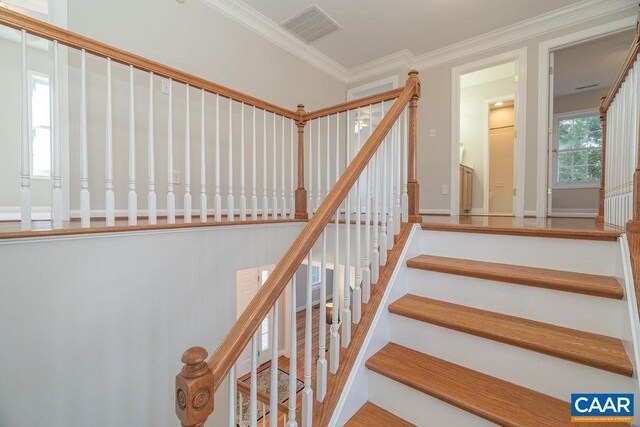 staircase featuring ornamental molding and visible vents