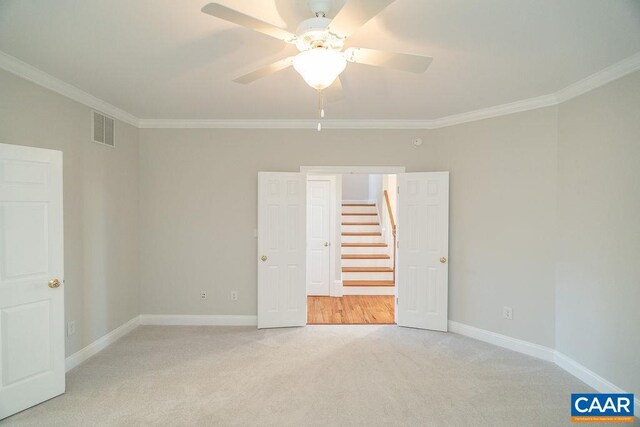 unfurnished bedroom with ornamental molding, visible vents, light carpet, and baseboards