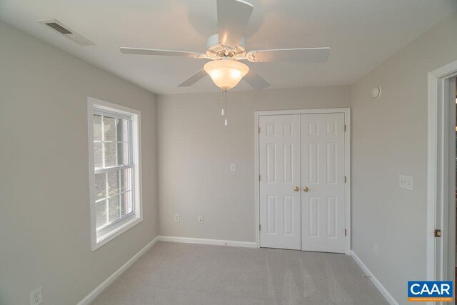 unfurnished bedroom with baseboards, visible vents, a closet, and light colored carpet