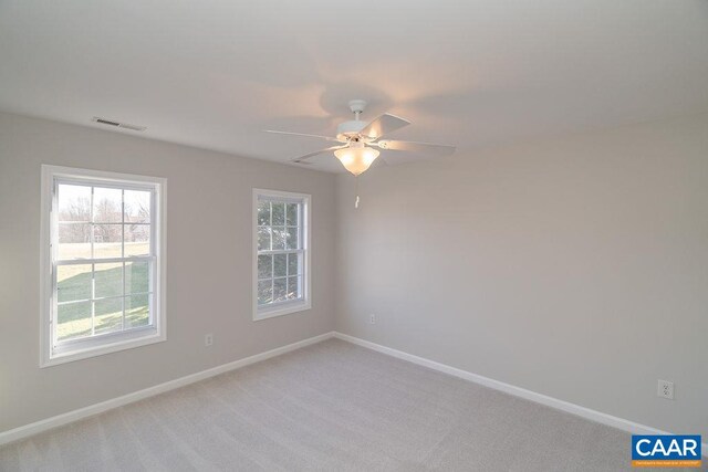 empty room featuring visible vents, baseboards, and light colored carpet