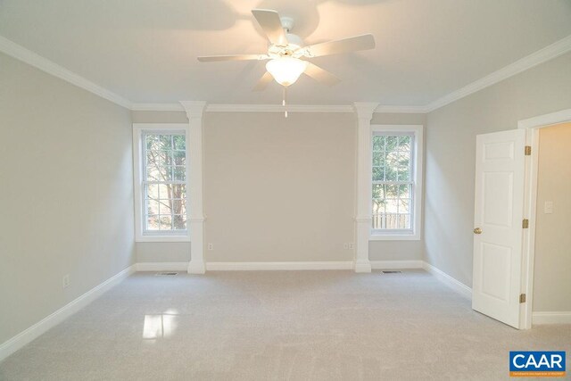 spare room featuring light carpet, a wealth of natural light, baseboards, and crown molding