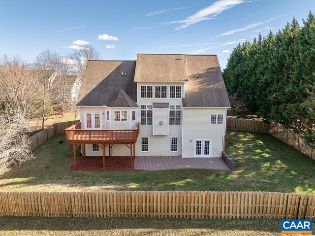 back of house with french doors, a fenced backyard, a yard, a wooden deck, and a patio area