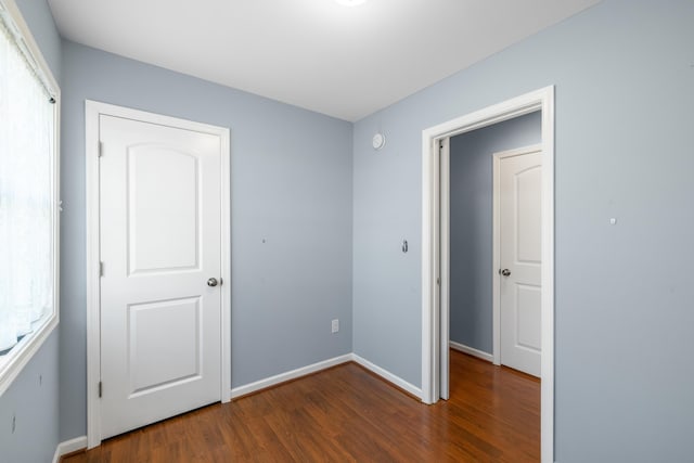 unfurnished bedroom featuring baseboards and wood finished floors