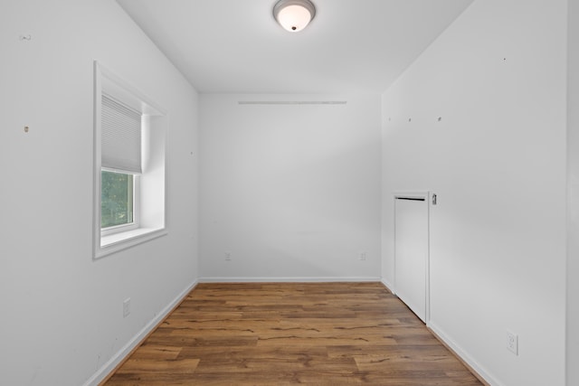empty room with baseboards and wood finished floors