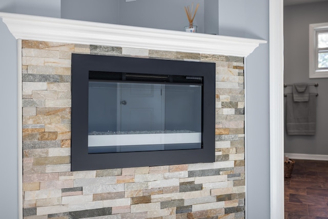 room details with a glass covered fireplace and baseboards