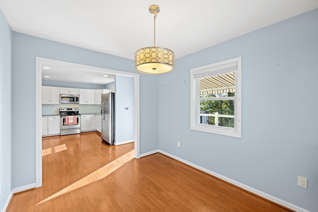 unfurnished dining area featuring recessed lighting, baseboards, and light wood finished floors