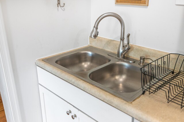 details with a sink, white cabinetry, and light countertops