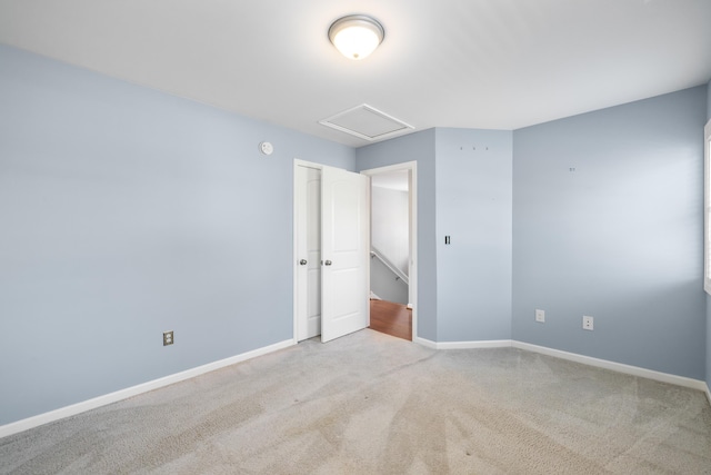 unfurnished bedroom featuring baseboards, carpet, and attic access