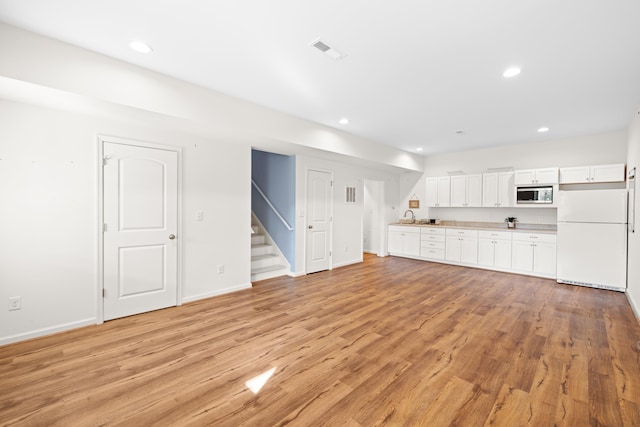 unfurnished living room with visible vents, recessed lighting, and light wood-style flooring