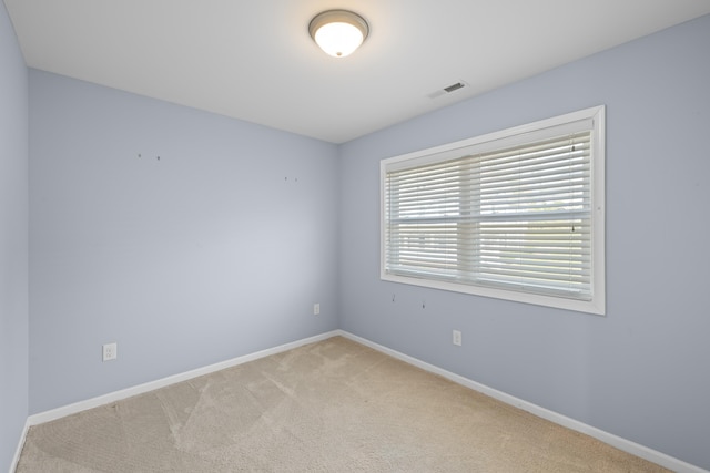 carpeted empty room with visible vents and baseboards