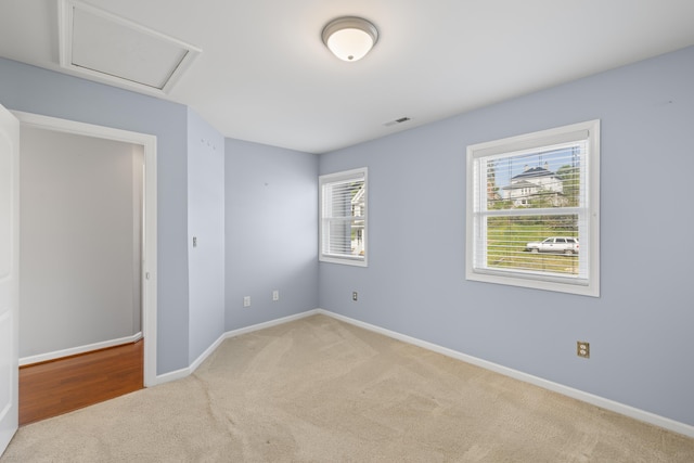 unfurnished bedroom with baseboards, carpet flooring, attic access, and visible vents