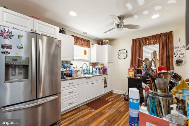 kitchen featuring stainless steel refrigerator with ice dispenser, a healthy amount of sunlight, and white cabinets