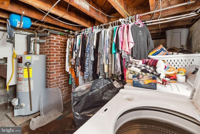 interior space featuring gas water heater, brick wall, and washing machine and clothes dryer