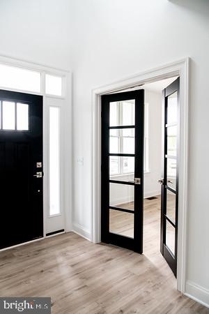 entrance foyer with light hardwood / wood-style floors and french doors