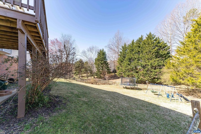 view of yard with a playground, a trampoline, and fence