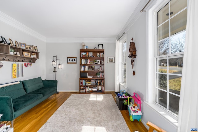 sitting room featuring crown molding, wood finished floors, and baseboards