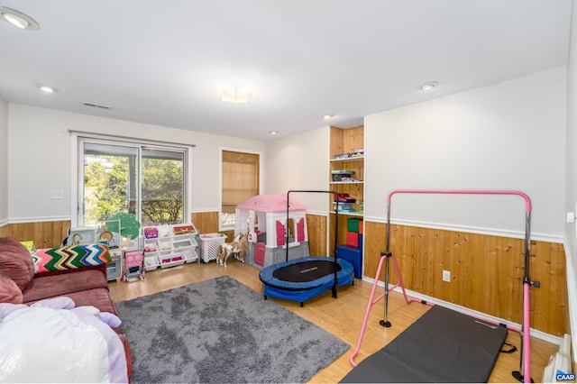 playroom with visible vents, wood walls, and wainscoting