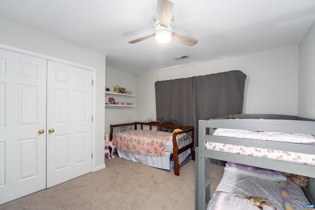 bedroom featuring visible vents, light colored carpet, a closet, and a ceiling fan