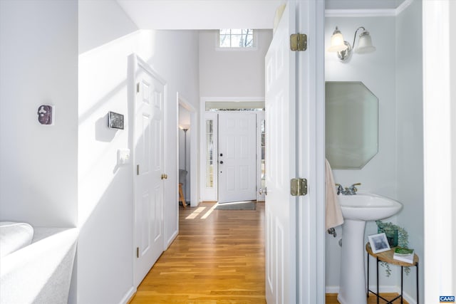 hallway featuring light wood finished floors and a sink