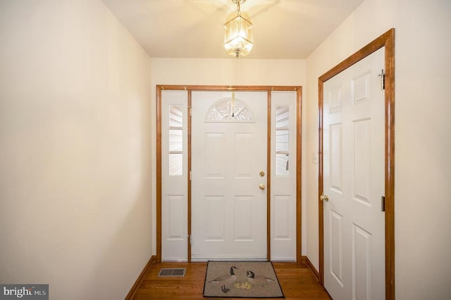 entrance foyer featuring visible vents, baseboards, and wood finished floors