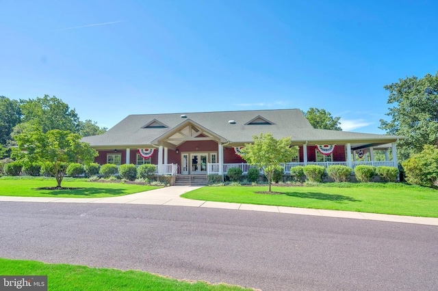 view of front of house featuring covered porch, a front yard, and french doors