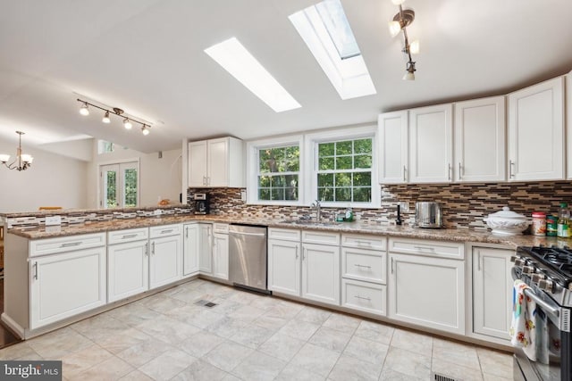 kitchen featuring lofted ceiling, stainless steel appliances, a sink, and a healthy amount of sunlight