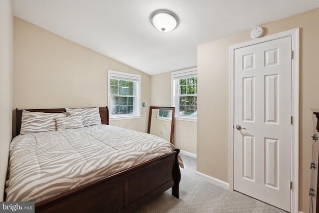 bedroom with lofted ceiling, carpet, and baseboards