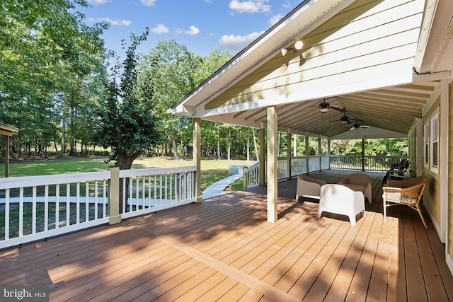 wooden deck featuring ceiling fan and a lawn