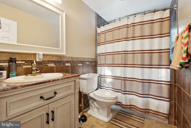 bathroom featuring curtained shower, toilet, vanity, tile walls, and wainscoting