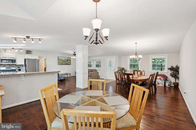 dining space with baseboards, dark wood finished floors, and ceiling fan with notable chandelier