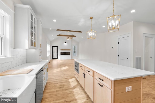 kitchen featuring lofted ceiling, visible vents, appliances with stainless steel finishes, light wood-type flooring, and tasteful backsplash