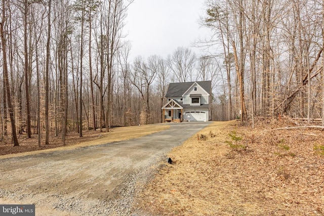 chalet / cabin featuring aphalt driveway and a garage