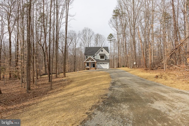 chalet / cabin featuring a garage and aphalt driveway