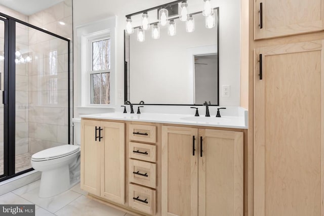 bathroom featuring double vanity, a stall shower, a sink, and toilet