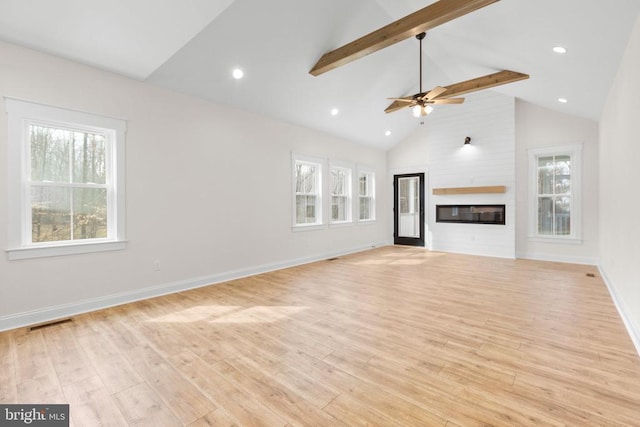 unfurnished living room featuring high vaulted ceiling, light wood-style flooring, a large fireplace, baseboards, and beam ceiling