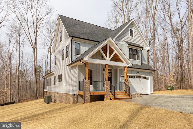 view of front of property featuring driveway, a garage, roof with shingles, a porch, and board and batten siding