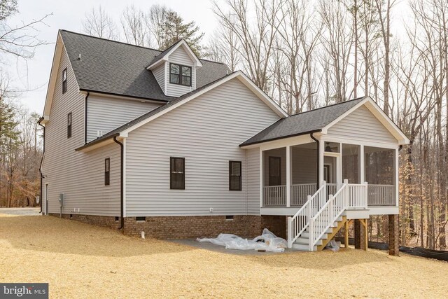 exterior space featuring stairs, a shingled roof, crawl space, and a sunroom