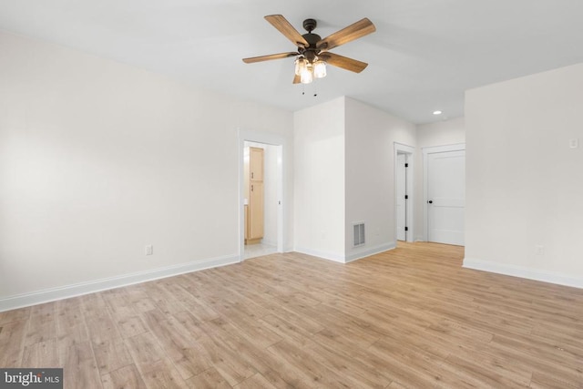 unfurnished room with a ceiling fan, light wood-type flooring, visible vents, and baseboards