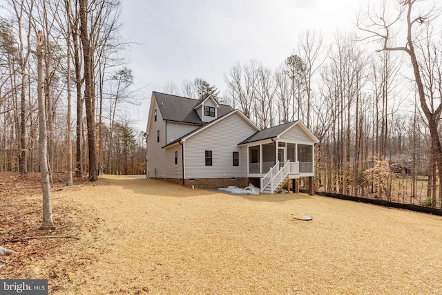 view of front of house with a sunroom, crawl space, stairway, and dirt driveway