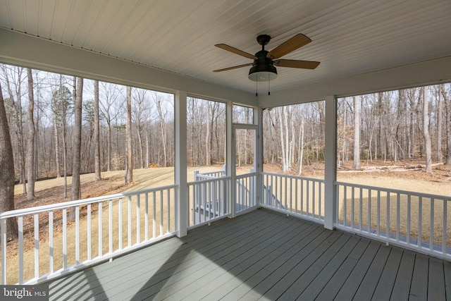 unfurnished sunroom featuring a ceiling fan and a wealth of natural light