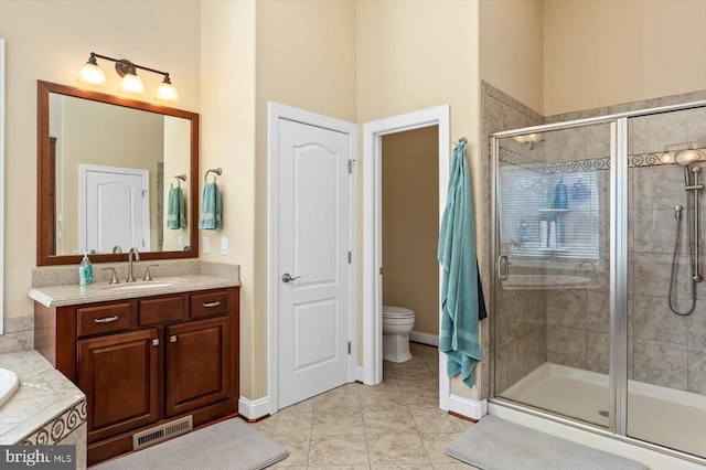 full bathroom featuring tile patterned flooring, toilet, vanity, visible vents, and a shower stall