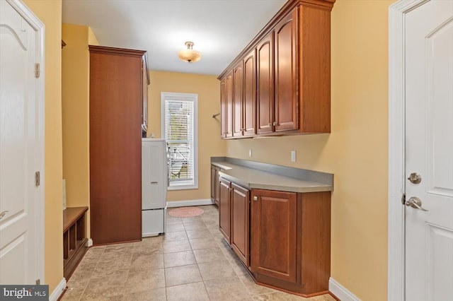 kitchen with brown cabinets, baseboards, and light tile patterned floors