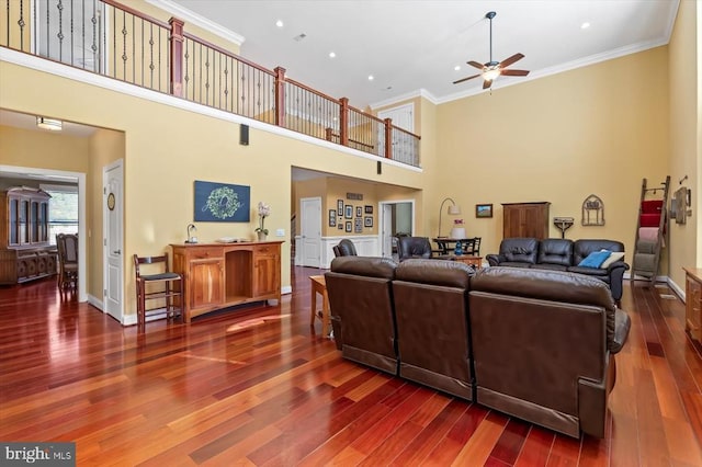 living room with ceiling fan, baseboards, crown molding, and wood finished floors